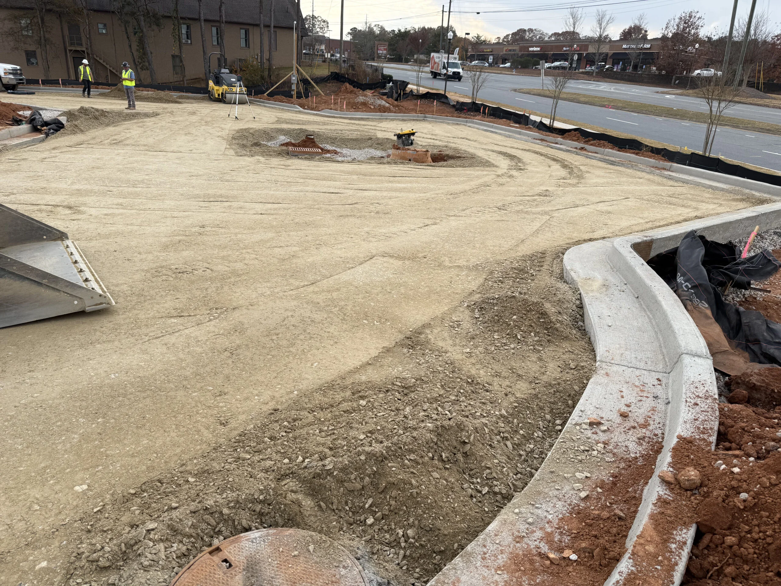 Prepared aggregate roadway base with concrete curb and gutter before asphalt paving